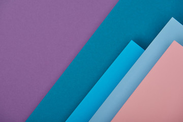 top view of purple, blue and pink paper sheets with copy space