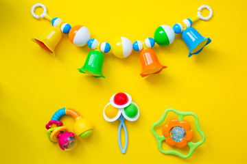 Kid's toys for a newborn baby. Various children's items for the game on a yellow background. Flat...
