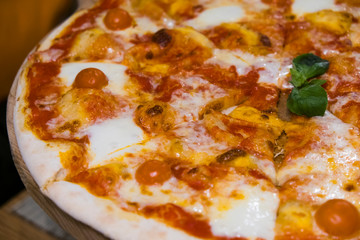 Food. Pizza with tomato, salami and olives. Pizza with ham, pepper and olives. Delicious fresh pizza served on wooden table.