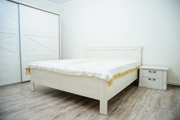 bedroom in soft light colors. big comfortable double bed in elegant classic bedroom