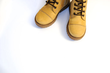 top view of a pair of yellow leather child shoes on a white background
