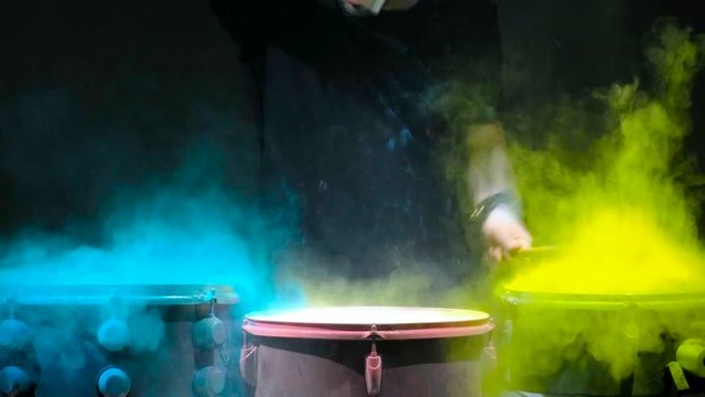 Holi powder bounces off the drum in the form of a shock wave, Close up. Black background
