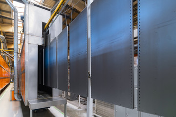 Powder coating line. Metal panels are suspended on an overhead conveyor line.