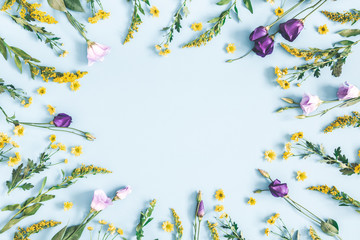 Flowers composition. Yellow and purple flowers on pastel blue background. Spring, easter concept. Flat lay, top view, copy space