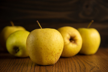 Yellow apple on the wooden vintage background