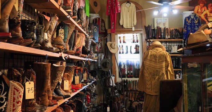 Antique store old fancy cowboy boots clothes Texas 4K. Historic tourist antique and collectible store. German settlement in Texas and National Historic District. Tourism for shopping, recreation.