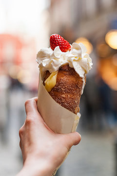 Woman holds in hand Trdlo or Trdelnik, it is a national street street food of Prague