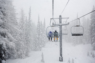 Skiers On Snowy Chairlift