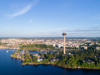 Aerial view from the lake. Observation tower and amusement park on the shore.