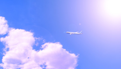 Naklejka na ściany i meble The plane against the sky near the clouds of white shining bright sun.