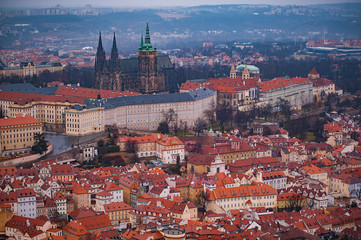 Obraz premium View on the red roofs of Mala Strana and St. Vitus Cathedral in Prague. Overcast weather