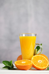 Glass of orange juice with oranges fruit on wooden table.