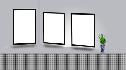 Mock up poster frames on wall above the table with a green colored flower vase. © mirzamlk