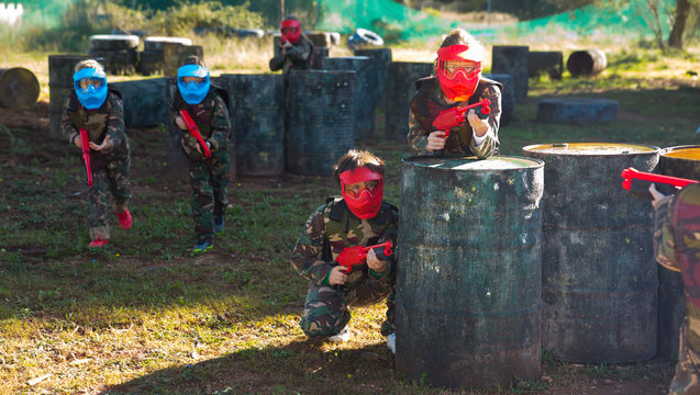 Group of cheerful kids playing paintball