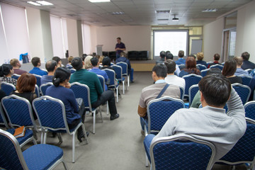 Fototapeta premium The speaker makes a report at a business meeting. Spectators in the conference room. Business and entrepreneurship.