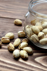 Roasted pistachios in a glass jar. Old wooden background. shallow depth of cut