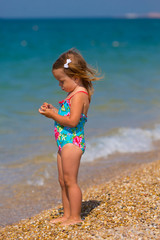Cute little girl playing on the seashore