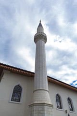 Fototapeta na wymiar Tower minaret on a background of clouds and sky