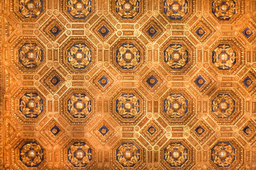Golden ceiling with fleur-de-lys inside an Italian house. Medieval architecture of Italy