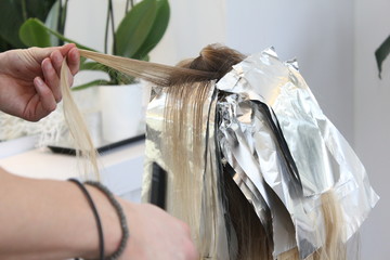 Balayage Trendstyle bei junger Frau blonden Haaren, Farbe wird augetragen, kühles blond, blondes....