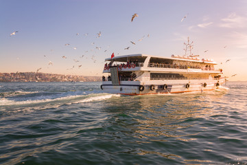 A tourist ship sails through the Bosphorus. Istanbul, Turkey. View of the city. Tourism and travel.
