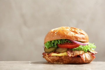 Delicious burger with bacon on table against grey background. Space for text