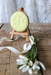 Spring composition of a bouquet of snowdrops and painted gingerbread. Rustic style.