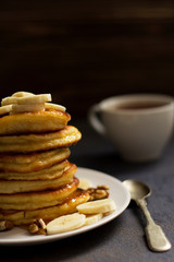 pancakes with honey and nuts, a cup of tea, breakfast, dark background