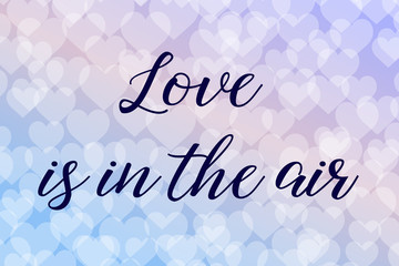 Love is in the air. Calligraphy saying. Bokeh background