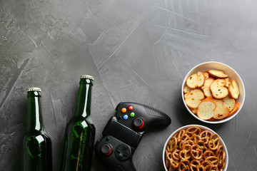 Flat lay composition with video game controller, snacks and space for text on grey background