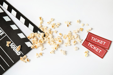 Clapperboard, popcorn and tickets isolated on white, top view. Cinema snack