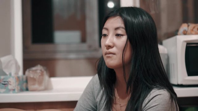 beautiful Asian girl sitting in the kitchen