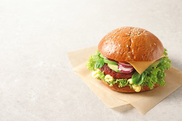 Tasty vegetarian burger with beet cutlet on light background. Space for text