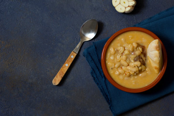 White bean stew, pasulj, bread, traditional Balkan cuisine, dark blue background, top view