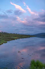 Obraz na płótnie Canvas Pink clouds and trees reflected at sunset in Wonder Lake, Denali National Park, Alaska, USA.