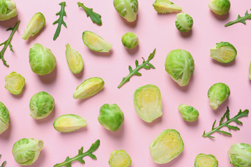 Fresh Brussels sprouts and arugula on color background, flat lay