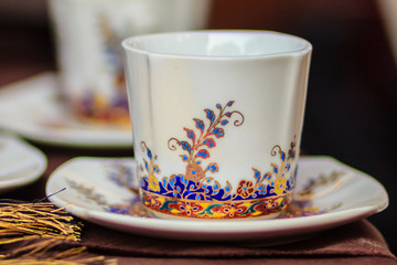 Vintage Thai's style porcelain coffee cup handmade. Beautiful traditional Thai five-colored porcelain ceramic coffee cup. Benjarong Porcelain coffee cup for sale in the flea market, Thailand.