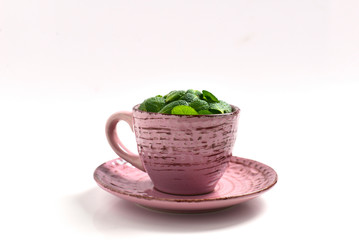 Mint leaves in a cup isolated on white background.