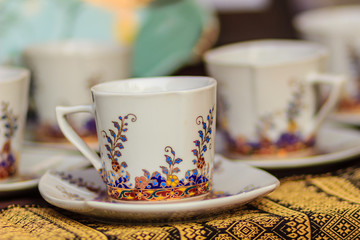 Vintage Thai's style porcelain coffee cup handmade. Beautiful traditional Thai five-colored porcelain ceramic coffee cup. Benjarong Porcelain coffee cup for sale in the flea market, Thailand.