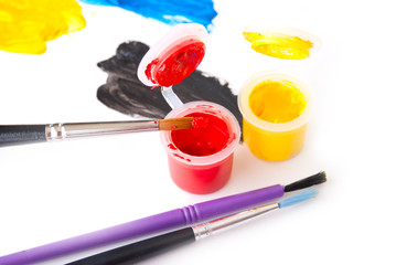 Colored paints and brushes on a white background