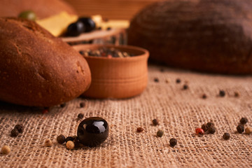 fresh bread baguette with olive oil, olives. cheese and rosemary on wooden background. Teasty breakfast