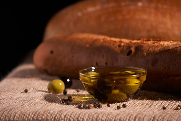 fresh bread baguette with olive oil, olives. cheese and rosemary on wooden background. Teasty breakfast