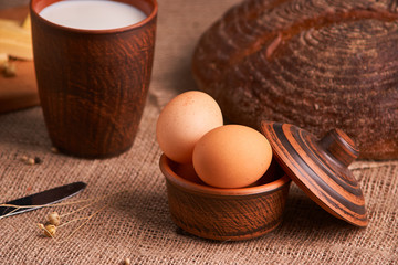 Eggs with bread and kitchen utensils on vintage wooden background. Tasty food