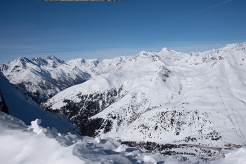 Obraz premium View of the mountains around the Tonale Pass from the Paradiso lodge during a winter sunny day. Tonale is a mountain pass between Lombardy and Trentino, near the Presena glacier