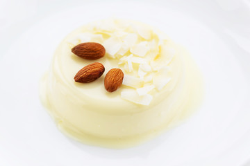 Panna cotta with almonds on a white table
