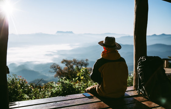 Young man traveler with phone while enjoying beautiful tropical sunrise in Thailand. travel concept.