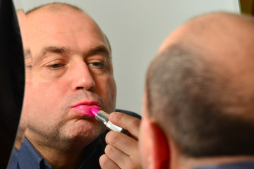 Adult uncle paints lips in a beauty salon, applies makeup.