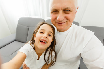 The happy girl and a grandfather making a selfie