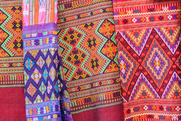 Fototapeta premium Colorful of native thai style silk and textiles pattern. Beautiful handmade woven fabrics thai silk fabric textured, with different native style patterns.