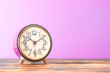 pink retro alarm clock on a wooden table